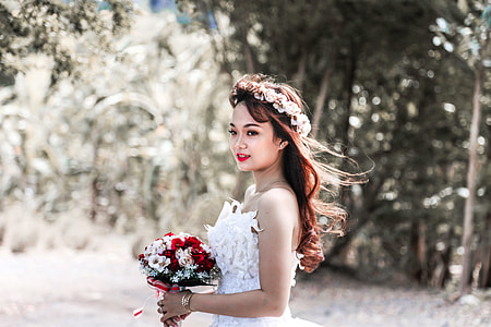 woman in white tube sweetheart bridal gown holding bouquet of flower thumbnail