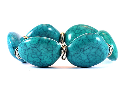 teal stone bracelet on white surface close up photography thumbnail