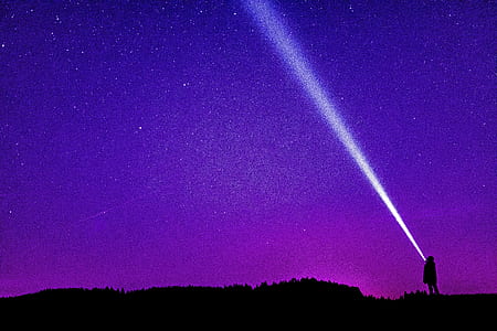 silhouette of person standing on open field under starry night thumbnail
