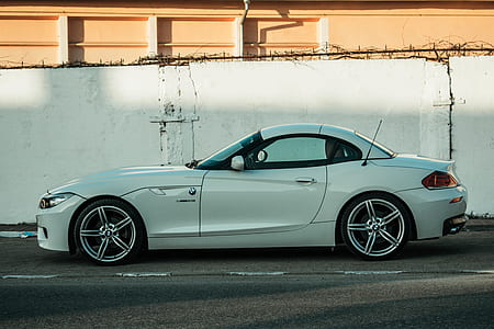 white coupe beside white wall thumbnail