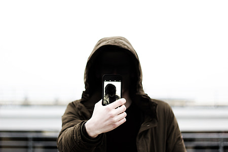 person in brown hoodie taking selfie outdoors thumbnail