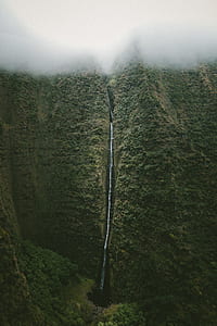 waterfalls near green trees under white clouds thumbnail