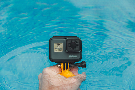 person holding black GoPro HERO thumbnail