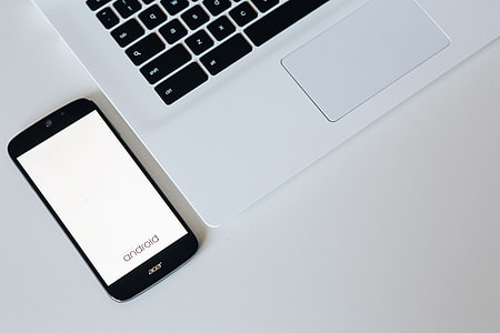 White laptop with smartphone and headphones thumbnail