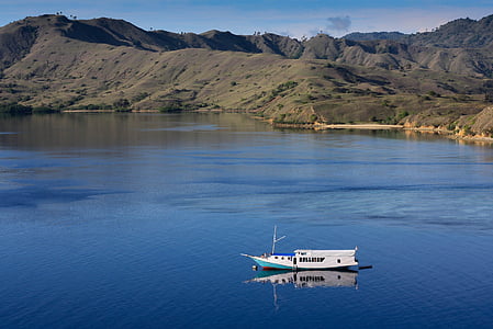 boat on body of water near mountains thumbnail