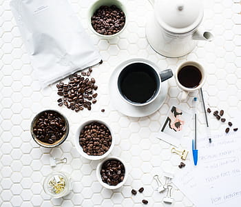 coffee cup near kettle surround by coffee beans in bowls thumbnail