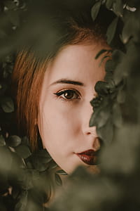 selective focus photography of woman behind green leafed plant thumbnail