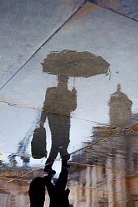 silhouette of man holding umbrella thumbnail