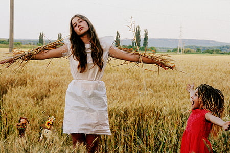 woman standing beside girl in red dress thumbnail