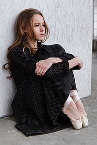 woman sitting beside wall thumbnail