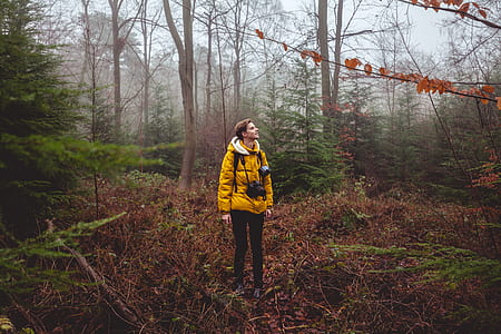 man in yellow hooded jacket standing on brown soil thumbnail