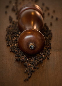 brown wooden pepper grinder surrounded by peppers thumbnail