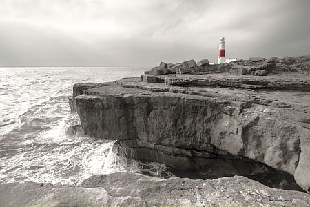 gray cliff and white and red lighthouse during daytime thumbnail