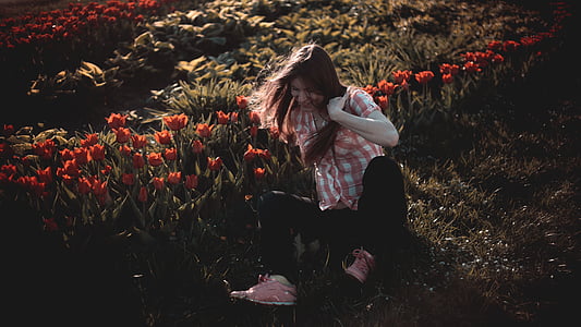 woman sitting beside on row of flowers thumbnail