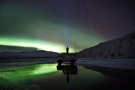 person standing on white vehicle during nighttime thumbnail