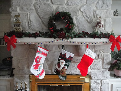 three Christmas socks hanging on fireplace thumbnail