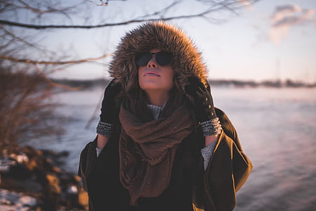 woman wearing black parka jeacket near body of water at daytime thumbnail