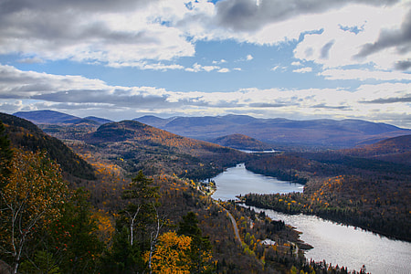 aerial photography of river and mountain ranges under gray and white clouds thumbnail