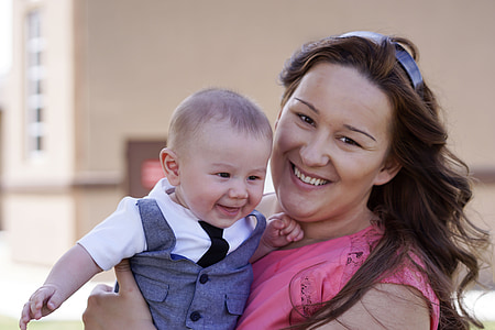 woman wearing pink sleeveless top carrying baby thumbnail
