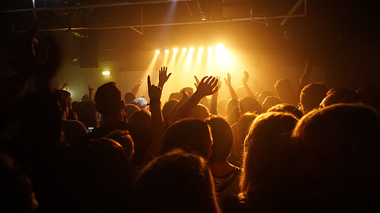 group of people gathered around inside dark room thumbnail
