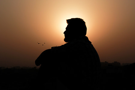 silhouette photography of man sitting thumbnail