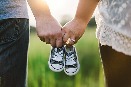 two person holding baby shoes thumbnail