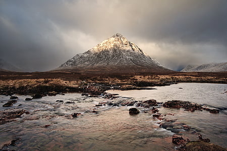 river near rocky mountain under gray sky thumbnail