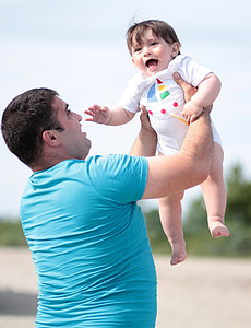 man lifting his child in field thumbnail