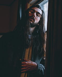 man wearing eyeglasses leaning on windowpane thumbnail