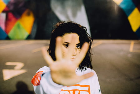 woman wearing white sweater raising her hand thumbnail
