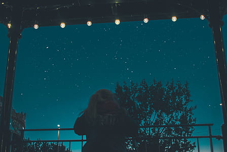 person leaning on barricade looking at the stars thumbnail