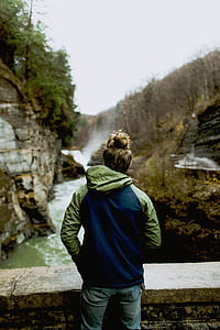 person standing near pavement facing body of water thumbnail