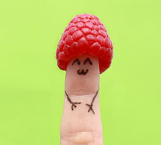 red raspberry on person's finger thumbnail