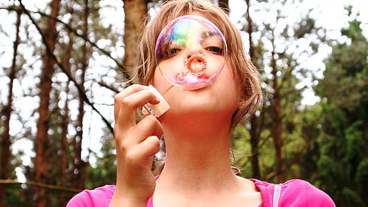 girl wearing pink top blowing balloon thumbnail