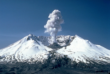 smoke coming out in snow capped mountain under blue sky thumbnail