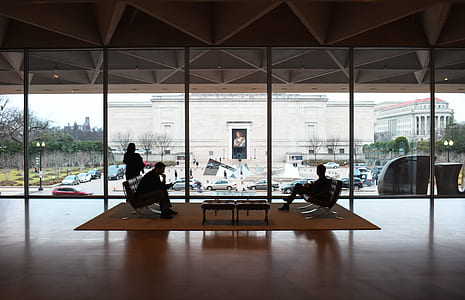 two persons sitting on gray and brown sofa thumbnail
