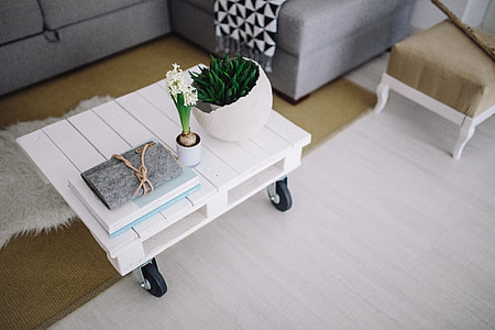 Small wooden table with a potted plant and a grey wallet thumbnail