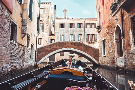 photography of boat between buildings thumbnail