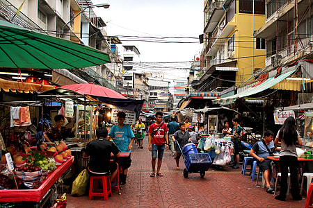 mass of people walking on isle surrounded by stores and stands beside buildings thumbnail