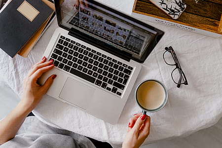 A woman works at a desk with a laptop and a cup of coffee thumbnail