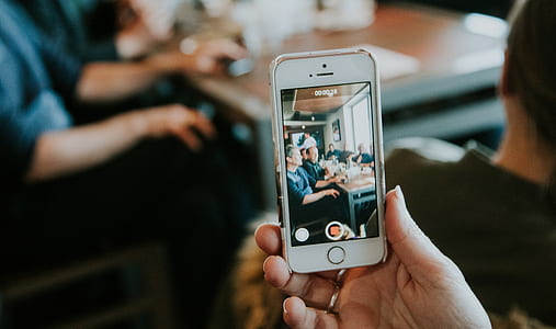 person holding iPhone taking photo thumbnail