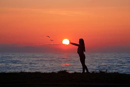 Photo of Woman Standing On Seashore During Dawn thumbnail