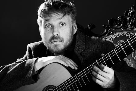 grayscale photo of man holding guitar thumbnail