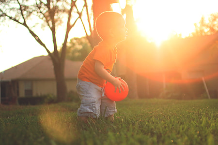 toddler holding red ball thumbnail