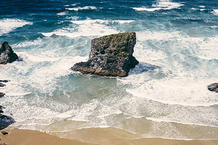 gray rock formation on body of water at daytime thumbnail