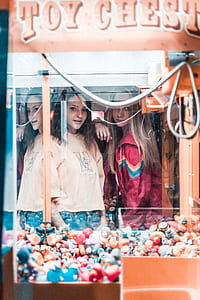 reflection of two women on Toy Chest claw machine glass enclosure thumbnail
