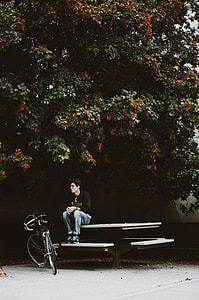 man sitting on bench facing bike thumbnail