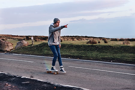 man riding skateboard in the middle of road thumbnail