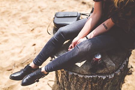 woman on blue leggings sitting on tree stump thumbnail