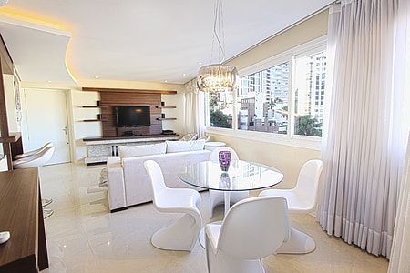 photo of round glass table top dining table with four white cantilever chairs during day time thumbnail